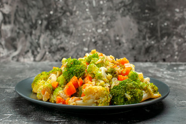 close up view healthy meal with brocoli carrots black plate with fork knife blog 1